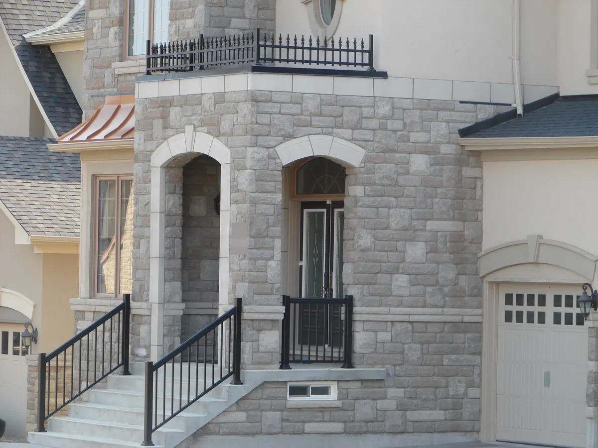 Decorative spear-top aluminum balcony on stone-cast heritage entry tower