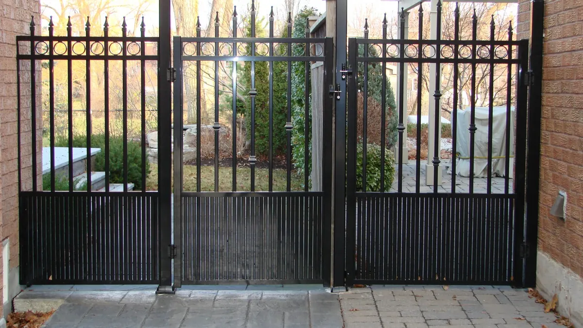 Decorative black aluminum spear-top gates with custom motif Burlington installation